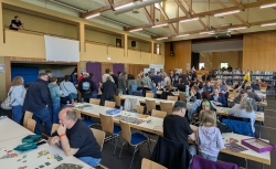 Volle Spieltische und eine Schlange beim Flohmarkt.